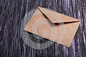 Envelope of Kraft paper. Love letter envelope. Wooden background. Social network.