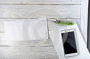 Envelope with a letter on the desktop. Knife, notebook and mobile phone.