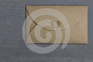 Envelope made of brown recycled paper on wood background