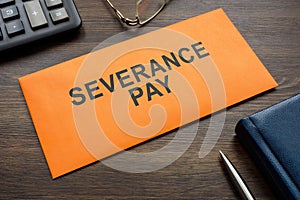 Envelope with sign severance pay on the desk.