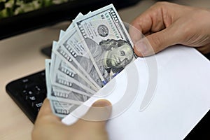Envelope with US dollars in male hands