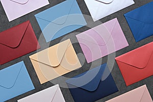 Envelopes of different colors on gray background. Top view, flat lay