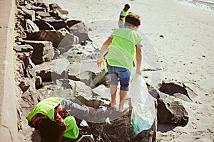 Environment, cleaning and children with dirt on beach for clean up, pollution and eco friendly volunteer. Sustainability