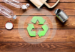 Environment concept with recycling symbol on wooden background top view mock up