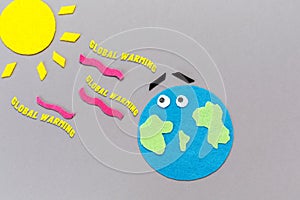 Environment disaster. The planet earth and the sun are carved out of felt. Gray background. Flat lay. The concept of global