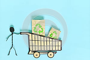 Environment friendly, sustainable and ecological shopping or consumerism concept. Stick figure pushing a shopping cart
