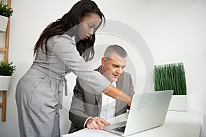 Environment of workers in their workplace consulting their computers and balance sheets