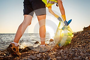 Environmental conservation. Bottom view of woman volunteer picking up garbage at beach. Concept of ocean& x27;s pollution