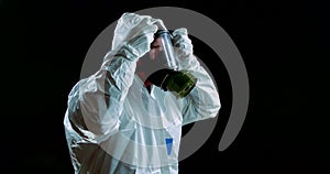 Environmental disaster a post-apocalyptic survivor in a gas mask on a dark background in a white protective suit