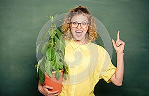 Environmental education. happy student girl with plant at blackboard. teacher woman in glasses at biology lesson. school