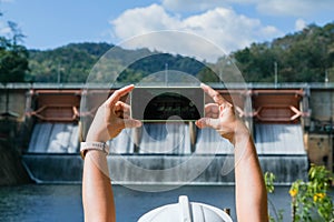 Environmental engineers use mobile phones to take pictures and record data analyzing dam water contaminants. Water and ecology