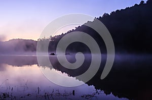 Environmental Friendly Outdoor Activity, Floating Bamboo Rafting in the morning in serene lake with sunlight and mist water