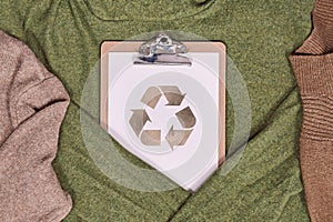 Environmental friendly produced clothing concept with sweaters and recycling symbol photo