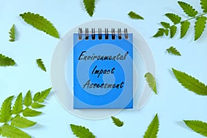 Environmental Impact Assessment or EIA concept. Word written on blue notepad. Beautiful minimalist flat lay