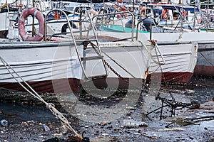 Environmental pollution - debris on the water surface between moored ships in the harbor