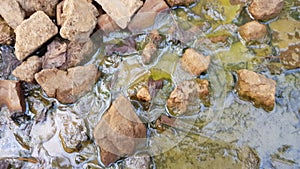 Environmental pollution, dirty water in a silt with stones and rubbish