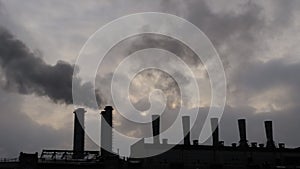 Environmental pollution - factory smokestack emitting smoke against grey sky