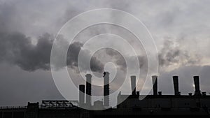 Environmental pollution - factory smokestack emitting smoke against grey sky