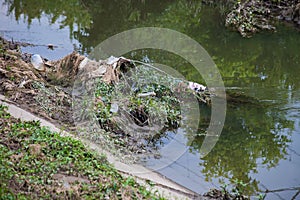 Environmental pollution, plastic, bags, bottles and trash in river