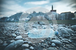 Environmental pollution: plastic bottle on the beach, urban city