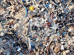 Environmental pollution. Sand beaches polluted with pieces of plastic waste. Micro plastics debris on the beach