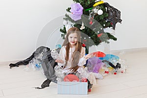 Environmental protection and pollution concept. Sad child carrier box with plastic trash over christmas tree background.