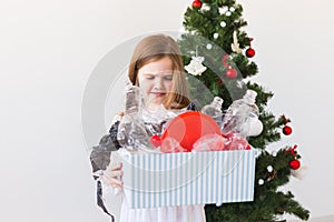 Environmental protection and pollution concept. Surprised child carrier box with plastic trash over christmas tree