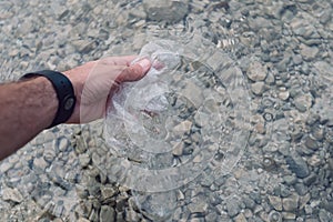 Environmentalist taking plastic bag from water