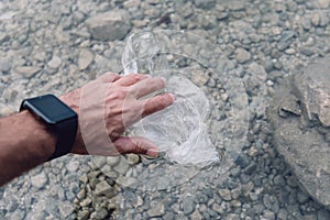 Environmentalist taking plastic bag from water photo