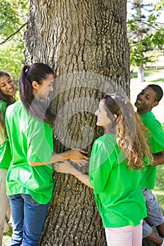 Environmentalists standing around tree trunk