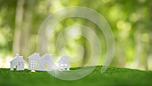 Environmentally eco-friendly real estate house. Small model building property home on grass in green nature ecology. Sustainable