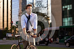 Environmentally friendly transportation. a businessman commuting to work with his bicycle.