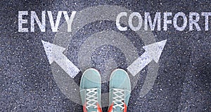 Envy and comfort as different choices in life - pictured as words Envy, comfort on a road to symbolize making decision and picking