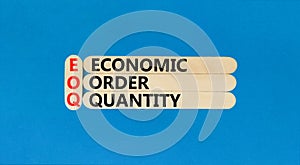 EOQ economic order quantity symbol. Concept words EOQ economic order quantity on wooden stick on a beautiful blue table blue