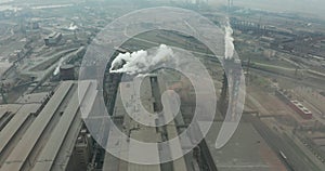 Epic aerial of high pipes with smoke emission. Plant pipes pollute atmosphere. Industrial factory pollution, smokestack