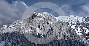 Epic aerial over cinematic mountains peaks on a sunny snowy winter day