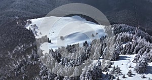 Epic aerial over cinematic mountains peaks on a sunny snowy winter day