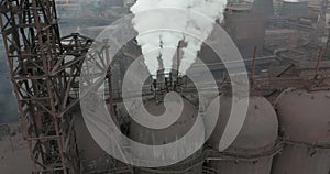 Epic aerial of pipes with white smoke emission. Plant pipes pollute atmosphere. Industrial factory pollution, smokestack