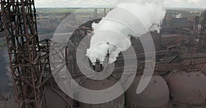 Epic aerial of pipes with white smoke emission. Plant pipes pollute atmosphere. Industrial factory pollution, smokestack