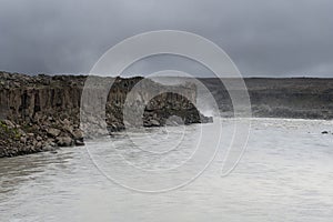 Epic basalt columns cliff near the dead river on a dark and cloudy day, Iceland