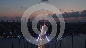 Epic Dolly forward through Istanbul Bosphorus Bridge Arch Illuminated in Red light at Night with Car traffic, Aerial