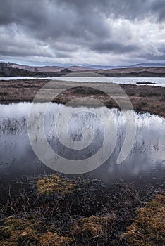 Epic dramatic landscape image of Loch Ba on Rannoch Moor in Scottish Highlands on a Winter morning