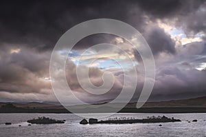 Epic dramatic landscape image of Loch Ba on Rannoch Moor in Scottish Highlands on a Winter morning