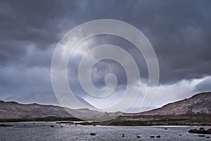 Epic dramatic landscape image of Loch Ba on Rannoch Moor in Scottish Highlands on a Winter morning