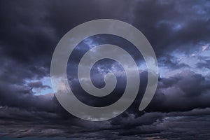 Epic Dramatic storm dark grey cumulus rain clouds against blue sky background texture, thunderstorm