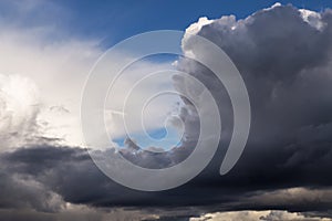 Epic dramatic Storm sky, dark grey and white cumulus clouds on blue sky background texture, thunderstorm. Darkness and light