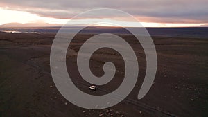 Epic Iceland Sunrise 4 Wheel Drive White Car Drives F-Road. Drone Flies to The Side and Swoops Over Vehicle Over Dirt Wide