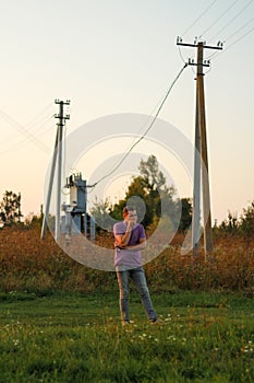 Epic portrait of young brunette man in purple polo shirt standing outdoor on nature background at summer day. Millennial