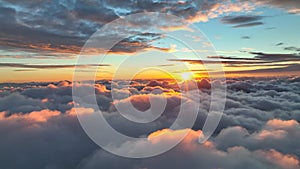 Epic sunset over the clouds. Warm sun sets over the horizon in clouds. Flight in the sky at sunset, view from window of