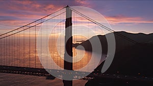 Epic sunset sky with rose golden clouds on background of Golden Gate Bridge 4K